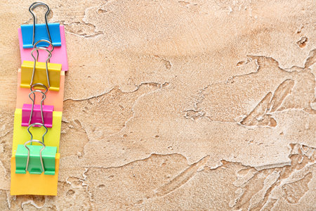 Sticky notes with colorful binder clips on color backgroundの写真素材