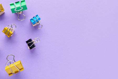 Different binder clips on color background