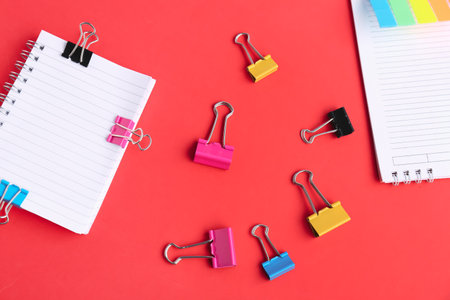 Notebooks with binder clips on red backgroundの写真素材