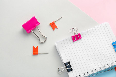 Notebook with binder clips and pins on paper sheets, closeupの写真素材