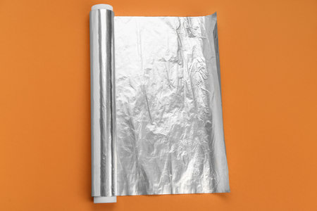Aluminum foil roll on orange backgroundの写真素材