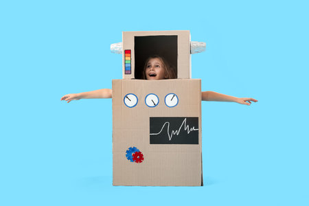 Little girl in cardboard robot costume on blue backgroundの写真素材