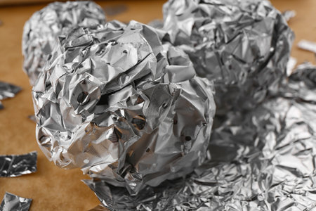 Crumpled balls of aluminum foil on table, closeupの写真素材