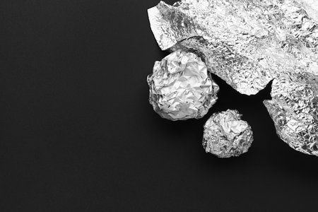 Crumpled balls of aluminum foil on dark backgroundの写真素材