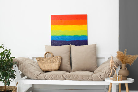 Painting of LGBT flag and couch near light wall in living roomの写真素材