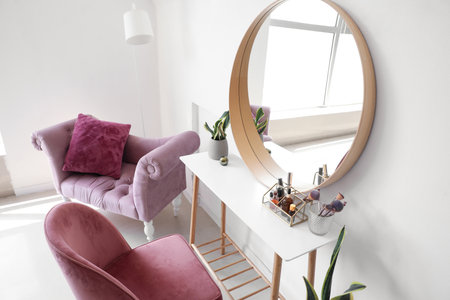 Interior of light makeup room with table, mirror and chairsの写真素材