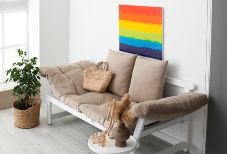 Painting of LGBT flag and couch near light wall in living roomの写真素材