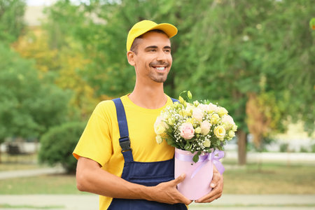 Delivery man with beautiful flowers outdoorsの写真素材