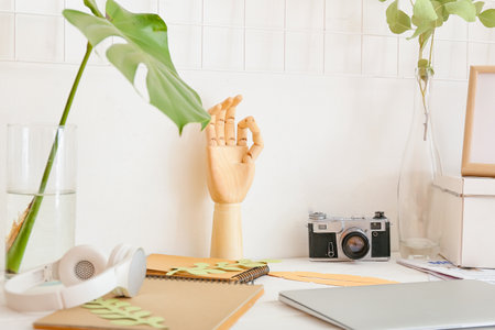 Wooden hand with photo camera on table in roomの写真素材