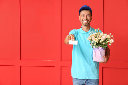 Delivery man with bouquet of flowers and business card on color backgroundの写真素材
