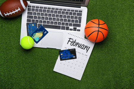 Laptop, credit cards and balls on color background. Concept of sports bet
