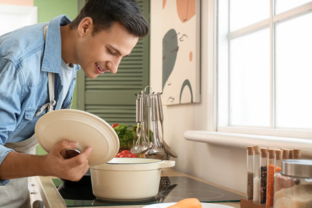 young man cooking food in the kitchenの写真素材