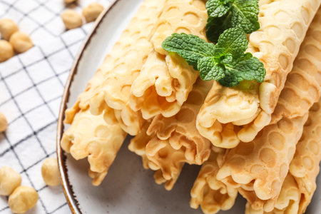 Plate with delicious wafer rolls and mint on napkin, closeupの写真素材