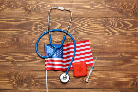 Stethoscope with pill container, syringe and USA flag on wooden backgroundの写真素材