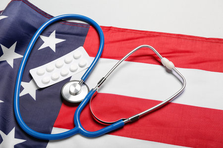 Stethoscope with pills and USA flag on white background, closeupの写真素材