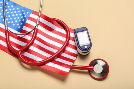 Stethoscope with pulse oximeter and USA flag on beige background, closeupの写真素材