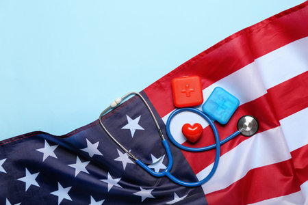 Stethoscope with pill containers, heart and USA flag on blue backgroundの写真素材
