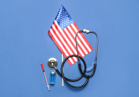 Stethoscope with vaccine, syringe and USA flag on blue backgroundの写真素材