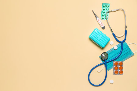 Stethoscope, thermometer, pills and medical mask on beige background. world health dayの写真素材