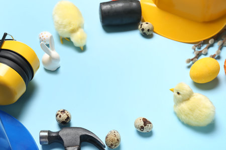 Frame made of builder's tools, chickens and Easter eggs on blue backgroundの写真素材