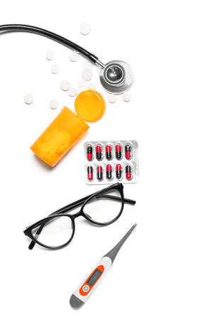 Pills with stethoscope, eyeglasses and thermometer on white background. world health dayの写真素材