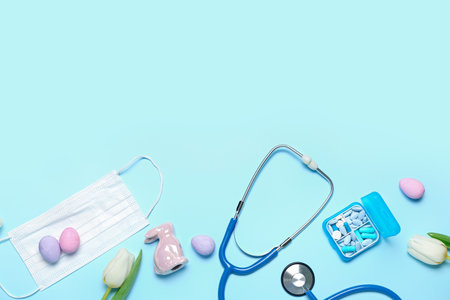 Stethoscope with medical mask, pills, tulips and Easter eggs on blue background. world health dayの写真素材