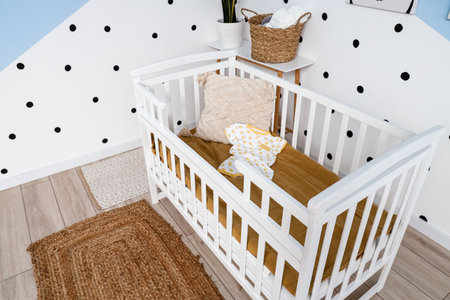 Crib with baby bodysuit in children's bedroomの写真素材