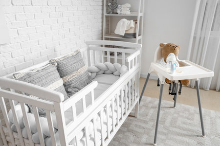 Interior of children's bedroom with crib and feeding chairの写真素材