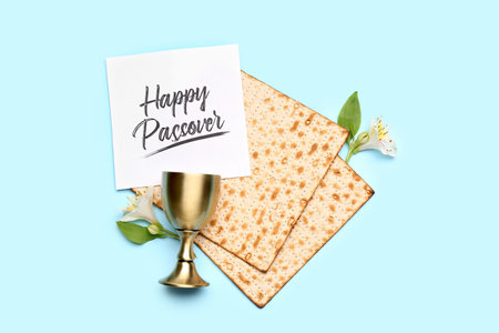 Composition with Jewish flatbread matza for Passover, card, cup and flowers on color backgroundの写真素材