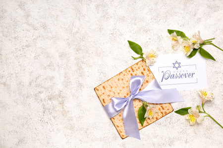 Composition with Jewish flatbread matza for Passover, greeting card and alstroemeria flowers on...