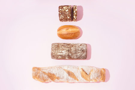 Fresh loaves of different bread on pink backgroundの写真素材