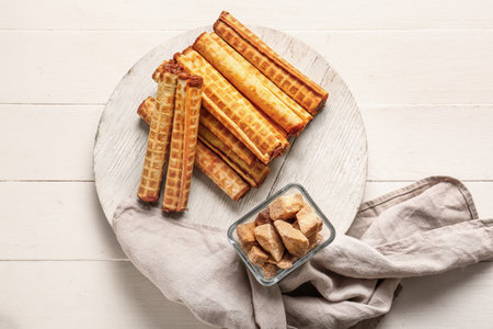 Board of wafer rolls with boiled condensed milk on white wooden backgroundの写真素材