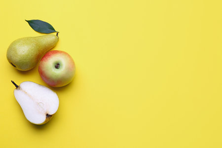 fresh pear and apple on yellow background
