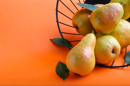 Basket with ripe pears on color background, closeupの写真素材