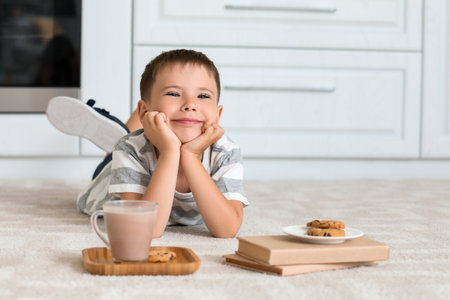 Little boy with tasty chocolate milk and cookies at homeの写真素材