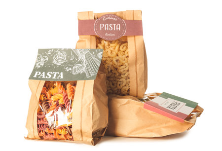 Bags with uncooked Italian pasta on white backgroundの写真素材