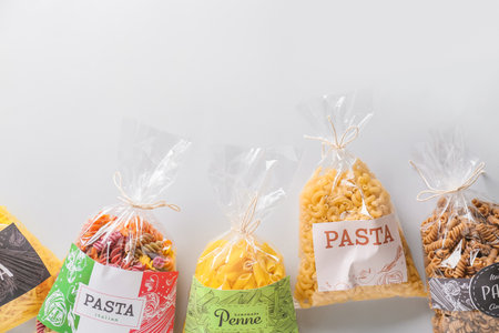 Bags with uncooked pasta on white backgroundの写真素材