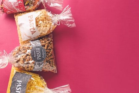 Bags with uncooked pasta on color backgroundの写真素材