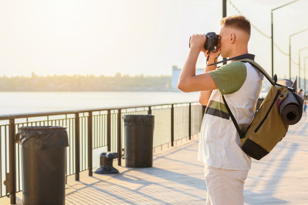 Male tourist taking photo on city streetの写真素材