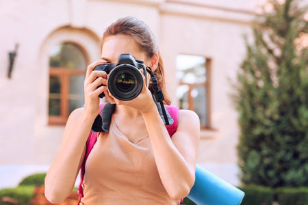 Female tourist taking photo on city street