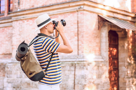Male tourist taking photo on city streetの写真素材