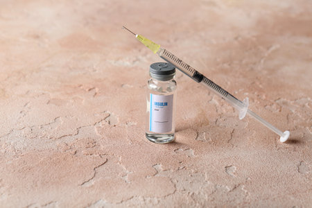 Bottle of insulin with syringe on color background. Diabetes conceptの写真素材