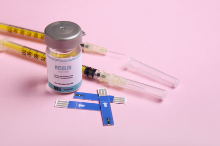 Bottle of insulin with syringes and test strips of glucometer on color background. Diabetes conceptの写真素材