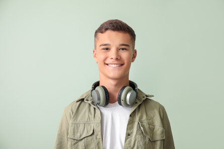 Teenage boy with headphones on color backgroundの写真素材