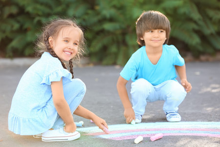 Little children drawing with chalk on asphaltの写真素材
