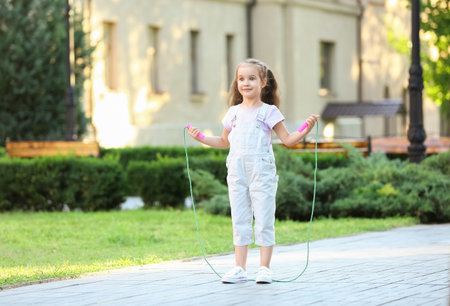 Cute little girl jumping rope outdoorsの写真素材