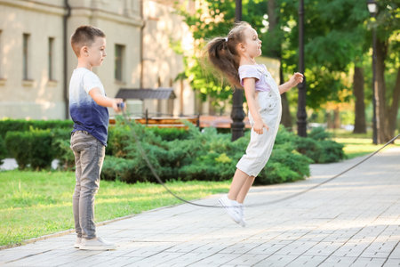Cute little children jumping rope outdoorsの写真素材