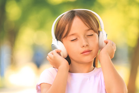 little girl listening to music in parkの写真素材