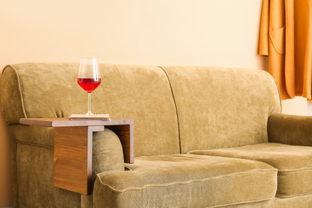 Glass of wine with notebook on armrest table in roomの写真素材
