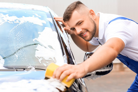 Male worker washing car outdoorsの写真素材
